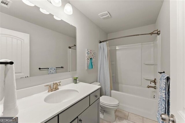 bathroom with tile patterned floors, toilet, vanity, and shower / bath combination with curtain