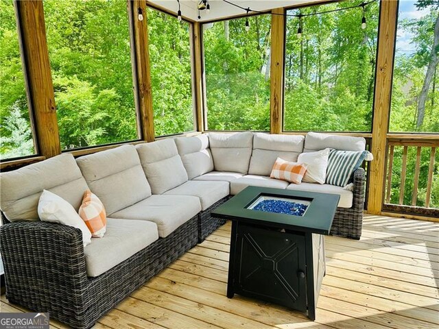 sunroom with an outdoor living space with a fire pit