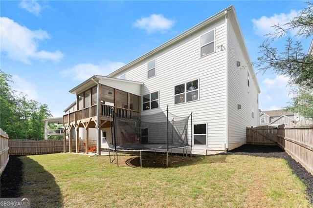 back of house with a trampoline and a sunroom