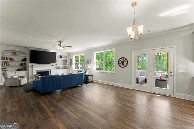 living room with a ceiling fan, baseboards, dark wood finished floors, crown molding, and a chandelier