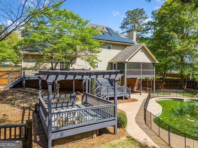 rear view of property featuring a sunroom, stairs, a pergola, and a fenced backyard