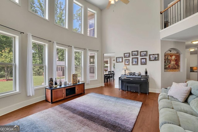 4100 Secret Shoals Way, Buford, GA 30518 - living area with a high ceiling, healthy amount of natural light, a ceiling fan, baseboards, and dark wood finished floors