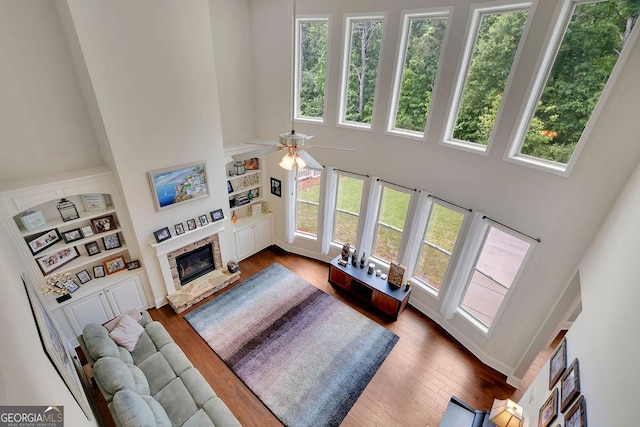 4100 Secret Shoals Way, Buford, GA 30518 - living room featuring a high ceiling, a fireplace, healthy amount of natural light, and dark wood-type flooring