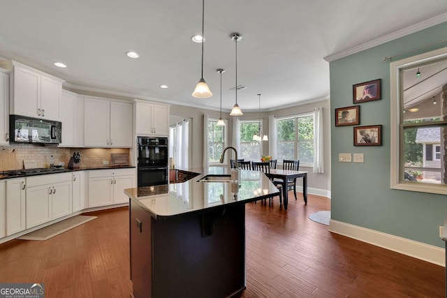 4100 Secret Shoals Way, Buford, GA 30518 - kitchen with black appliances, crown molding, tasteful backsplash, an island with sink, and white cabinets
