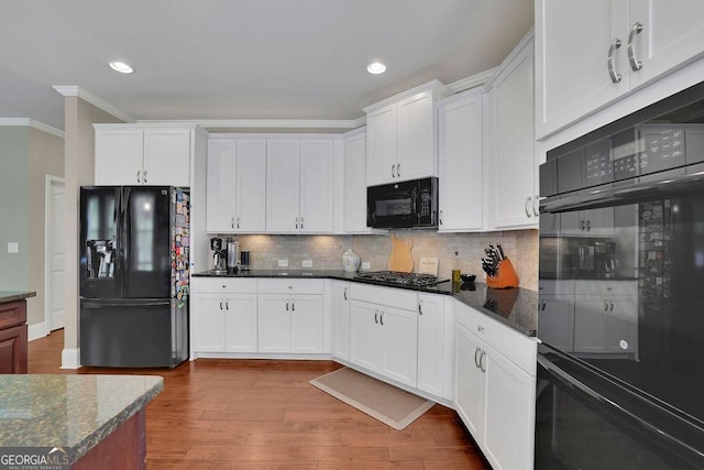 4100 Secret Shoals Way, Buford, GA 30518 - kitchen with black appliances, crown molding, backsplash, white cabinets, and wood finished floors