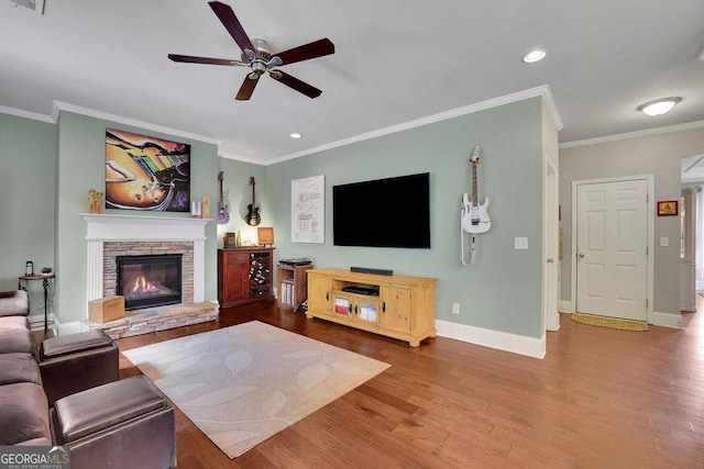 4100 Secret Shoals Way, Buford, GA 30518 - living area featuring a ceiling fan, ornamental molding, wood finished floors, baseboards, and a stone fireplace