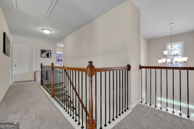 4100 Secret Shoals Way, Buford, GA 30518 - hallway with an upstairs landing, attic access, carpet flooring, a chandelier, and baseboards