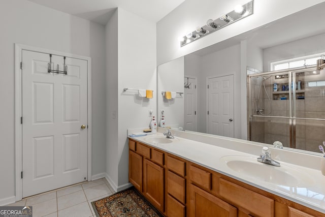 bathroom featuring a stall shower, double vanity, tile patterned flooring, and baseboards