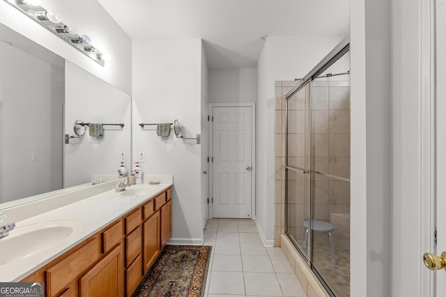 full bathroom with a shower stall, tile patterned flooring, double vanity, and baseboards