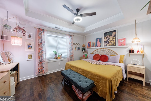 bedroom with a raised ceiling, wood finished floors, ornamental molding, baseboards, and ceiling fan