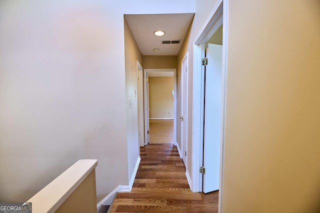 hall featuring wood finished floors, baseboards, and recessed lighting