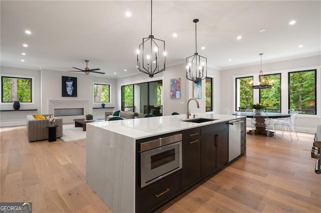 kitchen featuring a sink, a kitchen island with sink, appliances with stainless steel finishes, recessed lighting, and plenty of natural light