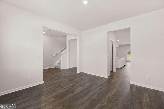 empty room with baseboards, dark wood-style flooring, stairway, and recessed lighting