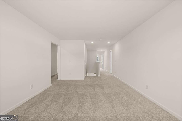 unfurnished room with light carpet, recessed lighting, and baseboards