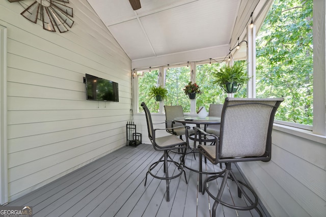 wooden terrace featuring outdoor dining area and ceiling fan