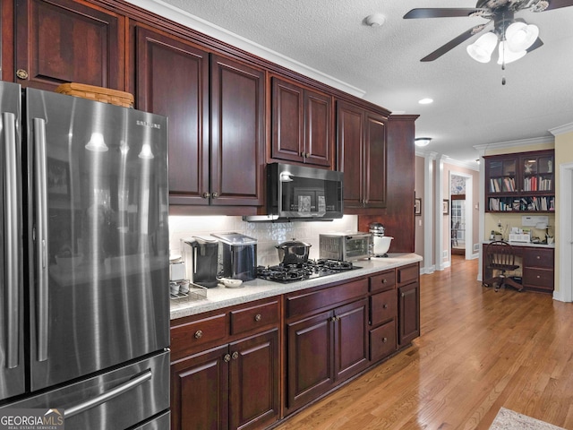 219 Eagles Landing Way, Mcdonough, GA 30253 - kitchen featuring stainless steel appliances, crown molding, ceiling fan, light countertops, and light wood-style flooring
