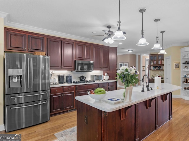 kitchen featuring appliances with stainless steel finishes, light wood-style floors, crown molding, pendant lighting, and ceiling fan