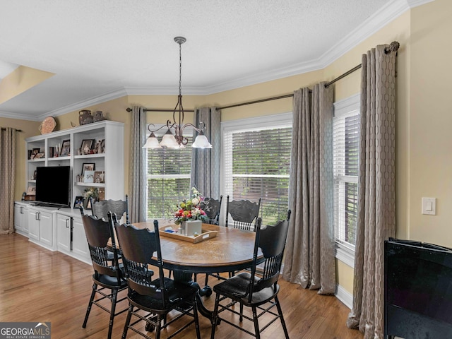 219 Eagles Landing Way, Mcdonough, GA 30253 - dining area featuring plenty of natural light, light wood-type flooring, a chandelier, and crown molding