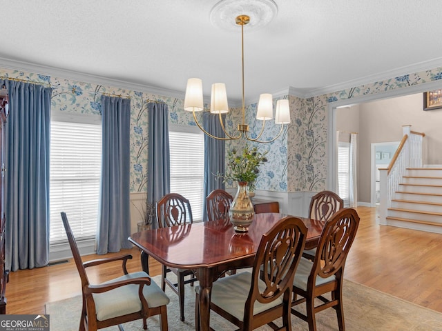 219 Eagles Landing Way, Mcdonough, GA 30253 - dining area with wallpapered walls, stairs, ornamental molding, a wainscoted wall, and light wood-style flooring