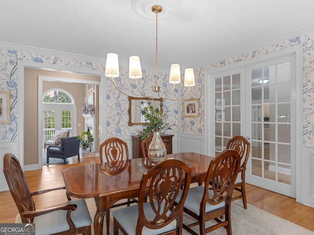 219 Eagles Landing Way, Mcdonough, GA 30253 - dining space featuring wallpapered walls, light wood-style flooring, wainscoting, crown molding, and french doors