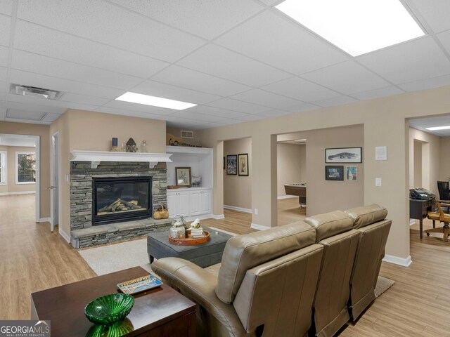 219 Eagles Landing Way, Mcdonough, GA 30253 - living room featuring light wood finished floors, a fireplace, and a paneled ceiling