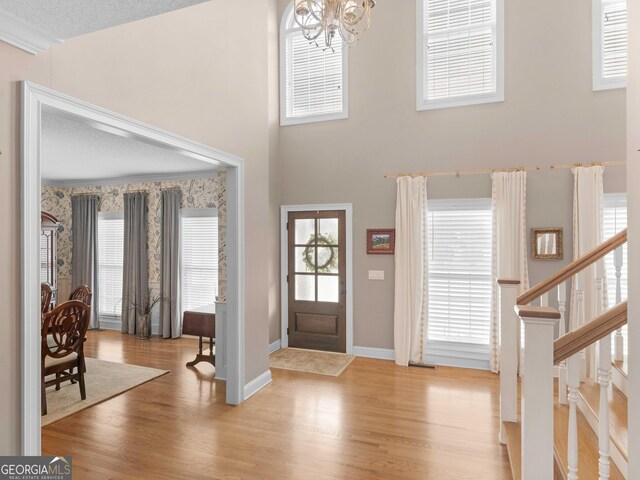 219 Eagles Landing Way, Mcdonough, GA 30253 - entrance foyer featuring a chandelier, wood finished floors, a towering ceiling, a textured ceiling, and stairway
