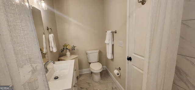 110 Forrest Ave, Jackson, GA 30233 - bathroom with marble look tiles, toilet, vanity, and baseboards