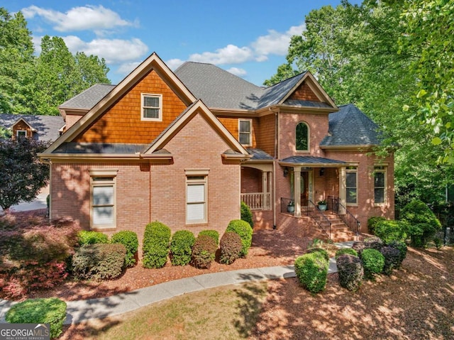 craftsman house with brick siding and a shingled roof