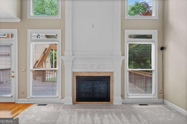 unfurnished living room with a fireplace, baseboards, and carpet floors