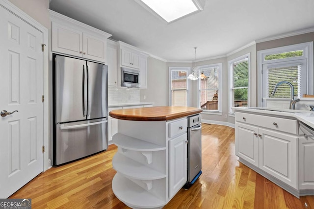 kitchen featuring appliances with stainless steel finishes, open shelves, white cabinetry, a sink, and light wood finished floors