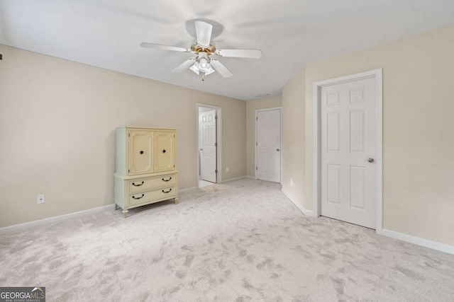 unfurnished bedroom featuring light carpet, baseboards, and ceiling fan