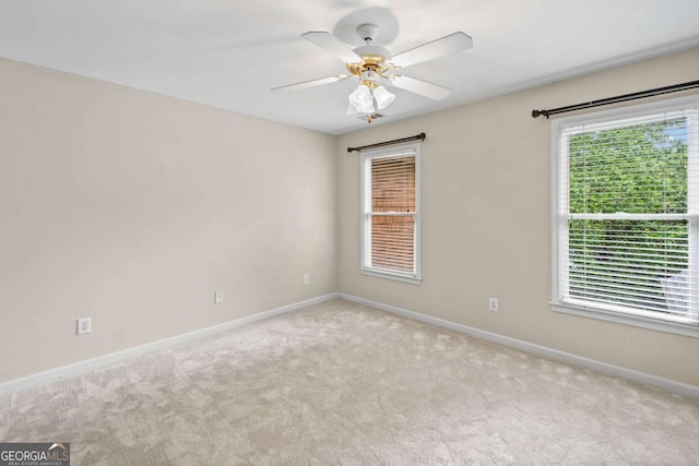 unfurnished room featuring carpet flooring, baseboards, and a ceiling fan