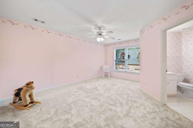 carpeted spare room with a ceiling fan