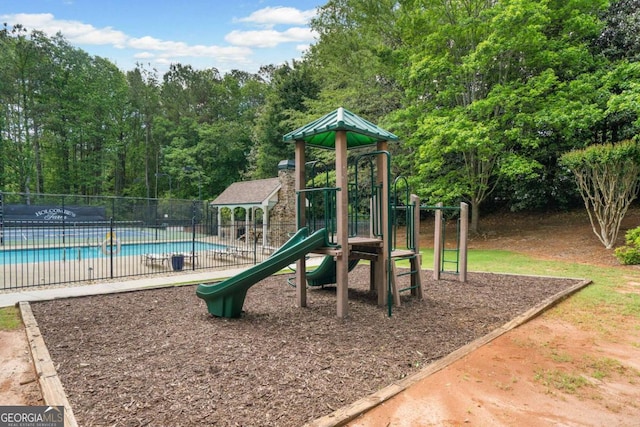 community play area featuring fence and a community pool