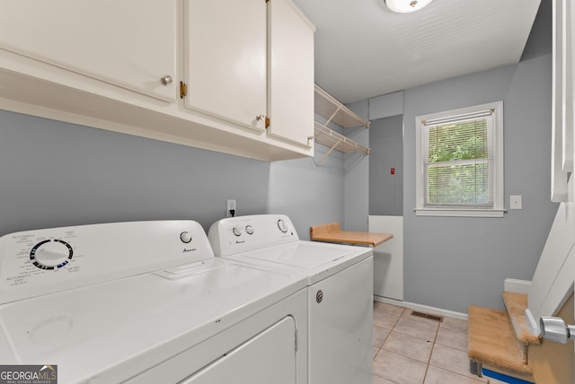 laundry room with washer and clothes dryer, cabinet space, electric panel, light tile patterned flooring, and baseboards
