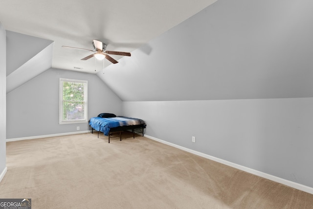 unfurnished bedroom with carpet, lofted ceiling, baseboards, and a ceiling fan