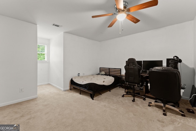 carpeted bedroom with ceiling fan, baseboards, and a desk