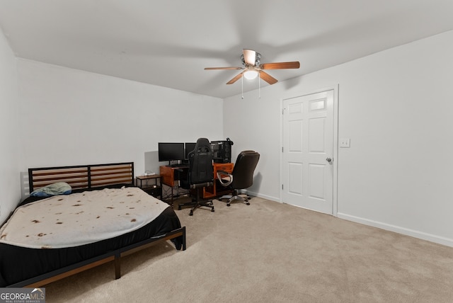 carpeted bedroom with baseboards, a ceiling fan, and a desk