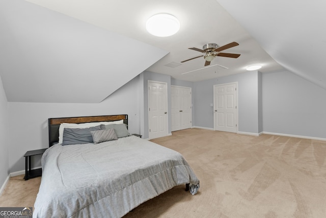 bedroom with light carpet, lofted ceiling, baseboards, and a ceiling fan