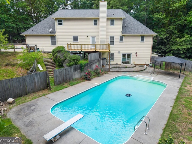 view of swimming pool featuring a diving board, fence, a patio, and a gazebo
