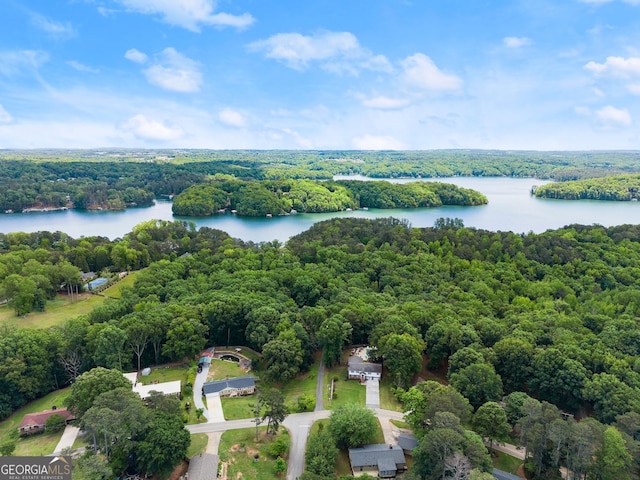 drone / aerial view of a heavily wooded area and a nearby body of water