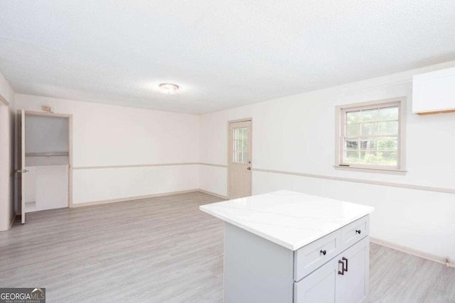 315 Henson Cir, Carrollton, GA 30117 - interior space featuring light wood-style floors, a kitchen island, baseboards, and white cabinets