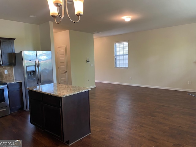 11813 Lovejoy Crossing Blvd, Hampton, GA 30228 - kitchen with stainless steel appliances, dark wood finished floors, light stone countertops, a chandelier, and a center island