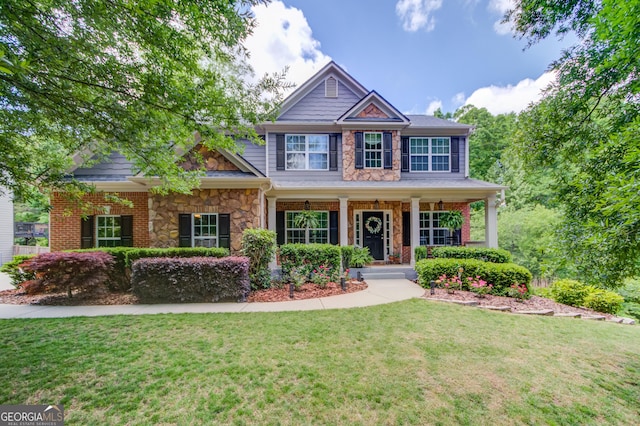 5960 Bridge Stone Ct, Cumming, GA 30028 - craftsman house featuring a front yard, stone siding, and a porch