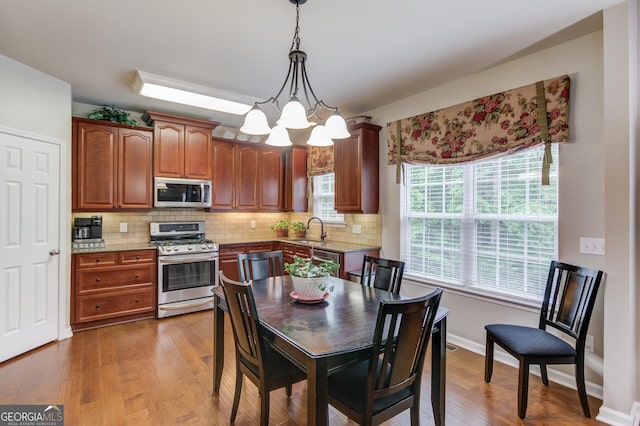 5960 Bridge Stone Ct, Cumming, GA 30028 - kitchen featuring stainless steel appliances, a sink, healthy amount of natural light, and decorative backsplash
