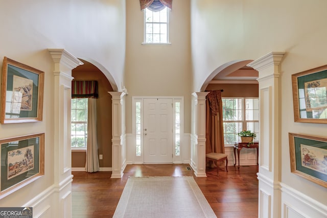 5960 Bridge Stone Ct, Cumming, GA 30028 - entryway with a high ceiling, dark wood-style flooring, ornate columns, and arched walkways