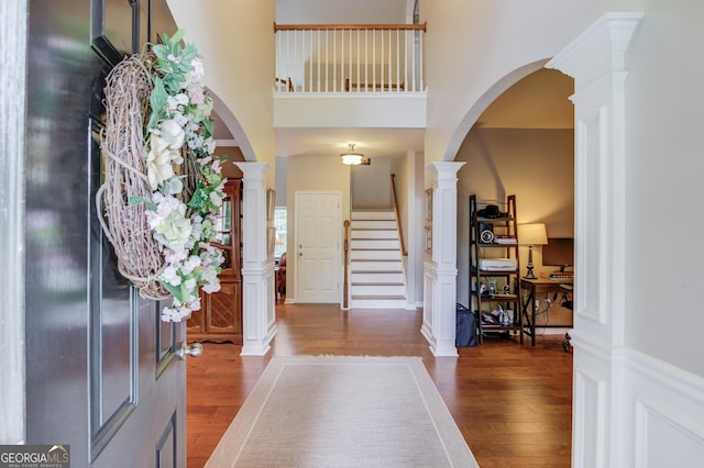 5960 Bridge Stone Ct, Cumming, GA 30028 - entryway with wood finished floors, stairway, a high ceiling, ornate columns, and arched walkways