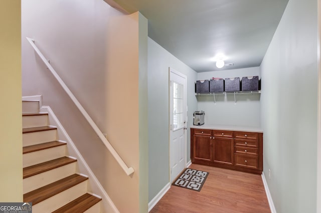 5960 Bridge Stone Ct, Cumming, GA 30028 - bar area featuring light wood finished floors, stairs, and baseboards