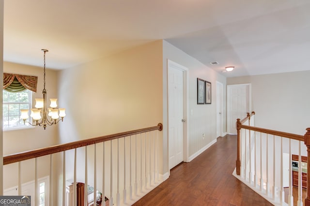 5960 Bridge Stone Ct, Cumming, GA 30028 - corridor with dark wood-style flooring, a chandelier, an upstairs landing, and baseboards