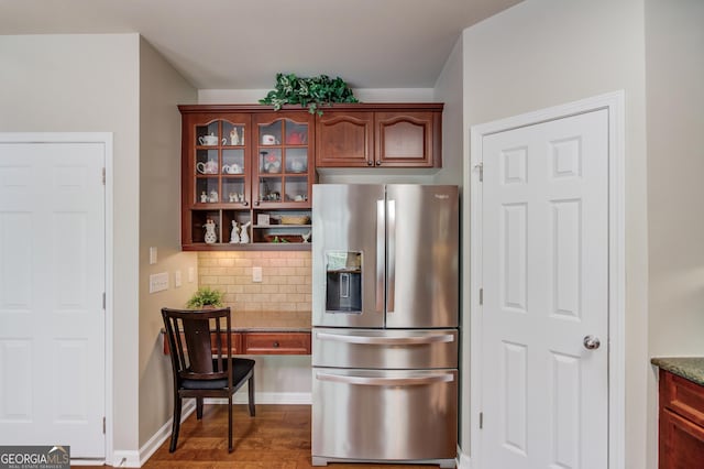 5960 Bridge Stone Ct, Cumming, GA 30028 - kitchen with stainless steel fridge with ice dispenser, decorative backsplash, glass insert cabinets, dark stone counters, and wood finished floors